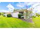 Backyard of home with beautiful green grass and landscaping at 9017 Se 119Th St, Summerfield, FL 34491
