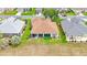 Aerial shot of a house with a screened-in lanai and a well-manicured lawn, backing onto a natural area at 9017 Se 119Th St, Summerfield, FL 34491
