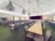 Spacious ballroom with tables, chairs, and a stage, perfect for events and gatherings at 9017 Se 119Th St, Summerfield, FL 34491