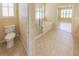 Bathroom featuring glass enclosed shower, soaking tub, and toilet at 9017 Se 119Th St, Summerfield, FL 34491