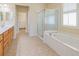 Bathroom featuring double vanities, a glass shower, and soaking tub with marble surround at 9017 Se 119Th St, Summerfield, FL 34491