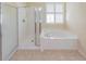 Bathroom featuring glass enclosed shower, soaking tub, and plantation shutters at 9017 Se 119Th St, Summerfield, FL 34491