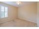 Empty bedroom with beige walls, carpet, ceiling fan and one window with shutters at 9017 Se 119Th St, Summerfield, FL 34491