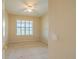 Bright empty bedroom features beige walls, carpet, ceiling fan and one window with shutters at 9017 Se 119Th St, Summerfield, FL 34491