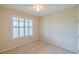 Empty bedroom features beige walls, carpet, a window with shutters and a ceiling fan at 9017 Se 119Th St, Summerfield, FL 34491