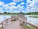 Scenic wooden dock and gazebo overlooking a serene lake in a residential community at 9017 Se 119Th St, Summerfield, FL 34491