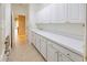 Functional laundry room with white cabinets, ample counter space, and utility sink at 9017 Se 119Th St, Summerfield, FL 34491