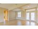 Open-concept living room with wood-look floors and french doors to the backyard at 9017 Se 119Th St, Summerfield, FL 34491