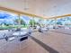 Covered outdoor seating area with tables and chairs, offering a relaxing view of the surrounding landscape at 9017 Se 119Th St, Summerfield, FL 34491