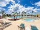 Resort-style pool and hot tub area with lounge chairs and lush landscaping under a sunny blue sky at 9017 Se 119Th St, Summerfield, FL 34491