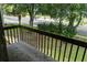 Exterior view from balcony with decorative wooden railing showcasing trees and a manicured lawn at 925 Fenton Ln # 18, Lakeland, FL 33809