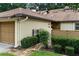 Cozy home exterior with a one-car garage, brick walkway, and neatly trimmed bushes at 925 Fenton Ln # 18, Lakeland, FL 33809
