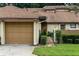 Charming townhome featuring a one-car garage, brick pathway, and manicured landscaping at 925 Fenton Ln # 18, Lakeland, FL 33809