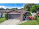 Charming home featuring a brick facade, well-maintained landscaping, and a two-car garage at 1523 Mariner Rd, Lakeland, FL 33803