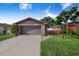 Charming home featuring a brick facade, well-maintained landscaping, and a two-car garage at 1523 Mariner Rd, Lakeland, FL 33803