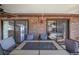 Covered patio featuring a decorative table, seating, ceiling fan and sliding glass doors to the home's interior at 1523 Mariner Rd, Lakeland, FL 33803
