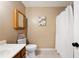 Simple bathroom with a classic vanity, framed mirror, toilet, and a shower with a curtain at 1081 Sunshine Sw Way, Winter Haven, FL 33880