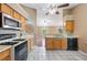 Kitchen showcasing stainless steel appliances, light wood cabinetry, and an open view to the living room at 1081 Sunshine Sw Way, Winter Haven, FL 33880