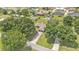 Aerial shot of the property featuring mature trees, a long driveway, and lush green lawn at 113 W Juliana Way, Auburndale, FL 33823