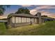 View of the back exterior with Florida room and spacious green lawn at 113 W Juliana Way, Auburndale, FL 33823