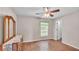 Bedroom with wood laminate flooring, ceiling fan and a window with decorative curtains for natural light at 113 W Juliana Way, Auburndale, FL 33823