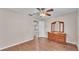 Bedroom featuring wood laminate flooring, ceiling fan and view to living area with bright natural light at 113 W Juliana Way, Auburndale, FL 33823