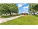 Long driveway and mature trees lead to a well-maintained home with a two-car garage at 113 W Juliana Way, Auburndale, FL 33823