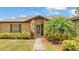 Charming front entrance with stone accents and lush tropical landscaping at 113 W Juliana Way, Auburndale, FL 33823
