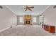 Large living room featuring a stone fireplace, carpet flooring, and ample natural light from multiple windows at 113 W Juliana Way, Auburndale, FL 33823