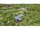 An aerial view shows the home nestled in a tranquil, tree-filled neighborhood at 1210 Heidi S Ln, Lakeland, FL 33813