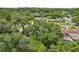 An aerial view shows the home's fenced in yard, pool and patio with mature trees at 1210 Heidi S Ln, Lakeland, FL 33813
