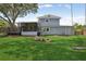 Backyard features a well-kept lawn, screened-in porch, and a large tree with a swing at 1210 Heidi S Ln, Lakeland, FL 33813