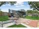 Landscaped backyard featuring a deck with stairs, brick patio, and well-maintained lawn at 1210 Heidi S Ln, Lakeland, FL 33813