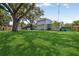 The property features a spacious green backyard with lush lawn and mature trees at 1210 Heidi S Ln, Lakeland, FL 33813