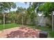 Large backyard with brick patio, wooden fence, and well-maintained landscaping at 1210 Heidi S Ln, Lakeland, FL 33813