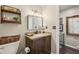 This bathroom has a dark wood vanity, modern fixtures, and framed mirrors at 1210 Heidi S Ln, Lakeland, FL 33813