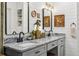 Bright bathroom with dual granite sinks, shiplap walls, decorative mirrors, and gold light fixtures at 1210 Heidi S Ln, Lakeland, FL 33813