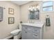 Bathroom featuring a vanity with marble countertop, gray cabinets, a window, and tiled shower in the background at 1210 Heidi S Ln, Lakeland, FL 33813