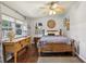 Bedroom with wood floors, a ceiling fan, large window, and a stylish dresser and bed at 1210 Heidi S Ln, Lakeland, FL 33813