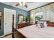 Cozy bedroom features a wooden four-poster bed, a ceiling fan, and a traditional dresser with mirror at 1210 Heidi S Ln, Lakeland, FL 33813