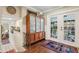 Entryway featuring a glass paneled cabinet, hardwood floors, and access to an outdoor space at 1210 Heidi S Ln, Lakeland, FL 33813