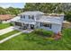 Aerial view of a charming two-story home with a well-manicured lawn and mature trees at 1210 Heidi S Ln, Lakeland, FL 33813