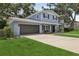 Two-story home with a well-manicured lawn, attached garage, and inviting front entrance at 1210 Heidi S Ln, Lakeland, FL 33813
