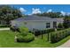 Well-manicured backyard featuring a lush lawn, carefully trimmed hedges, and a secure black aluminum fence at 128 Melissa Trl, Auburndale, FL 33823