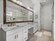 Bright bathroom with dual sinks, white cabinets, and framed mirrors, a glass shower and separate tub at 128 Melissa Trl, Auburndale, FL 33823