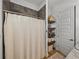 Bathroom with dark tiled shower, linen closet, and wood shelves at 128 Melissa Trl, Auburndale, FL 33823