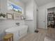 Bright bathroom featuring a modern soaking tub, wood-look tile flooring, and a walk-in closet at 128 Melissa Trl, Auburndale, FL 33823