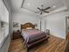 Spacious bedroom featuring hardwood floors, a ceiling fan, and a tray ceiling with recessed lighting at 128 Melissa Trl, Auburndale, FL 33823