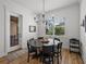 Bright dining room features a stylish chandelier, round table with seating for six, and natural light at 128 Melissa Trl, Auburndale, FL 33823