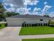 Spacious home with a two-car garage, concrete driveway, manicured lawn and manicured hedges at 128 Melissa Trl, Auburndale, FL 33823